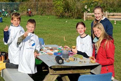 Chips, Pommes und Reibekuchen sind das eine, aber Kartoffeln sind auch Kreativ-Werkzeuge beim Stempeln auf Stoffbeutel. Das machen hier Lena, Imke und Laura aus der Mint-Klasse 8 der MKG mit Zweitklässlern der St.-Georg-Grundschule. Foto: Alfred Riese