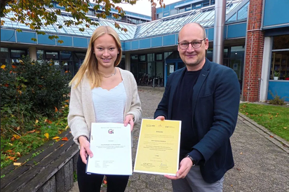 Janne Lagemann-Kohnhorst schrieb eine 16-seitige Facharbeit, in der sie die Zukunftsfähigkeit von Biogasanlagen untersucht hat. Von der Hans-Riegel-Stiftung wurde die Schülerin der Maximilian-Kolbe-Gesamtschule hierfür mit einem ersten Preis belohnt. Schulleiter Maarten Willenbrink hält stolz die Urkunde in die Kamera. Foto: Katja Niemeyer
