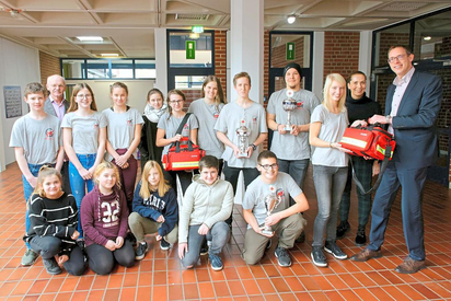 Taschen sind da, Inhalt folgt: Mitglieder des Schulsanitätsdienstes der Gesamtschule bekommen Unterstützung von Andre Dolle (rechts) von der Sparkasse. Daneben Esther Kuck, Koordinatorin des Diensts, links Schulleiter Karl Watermann. Foto: Alfred Riese