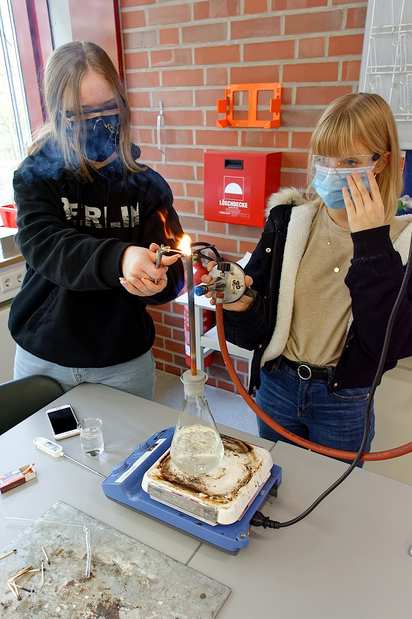 "MINTiG"-Thema Zündtemperatur: Ist der Wasserdampf heiß genug, kann man damit Streichhölzer entzünden, zeigen Charlotte (rechts) und Finja für das digitale Experimentier-Angebot für Grundschulen. Foto: Gemeinde Saerbeck