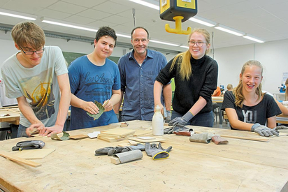 Handarbeit steckt in den Upcycling-Werkstücken, die Innenarchitekt Oliver Schübbe (M.) mit MKG-Schülern aus gebrauchtem Material herstellt. Foto: Alfred Riese