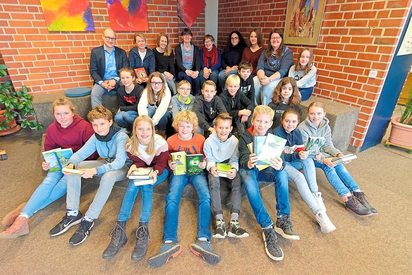 Die Klassensieger des Vorlesewettbewerbs (vordere Reihe) mit dem Schulsieger Hennes Schmitz (3. von rechts), ihren Begleitern (mittlere Reihe), den Jurymitgliedern und Organisatorinnen und Maarten Willenbrink, kom. Schulleiter. Foto: Alfred Riese