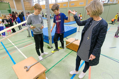 Balanceakt eines Grundschülers mit Lehrerin zur Linken und Sporthelfer von der Gesamtschule zur Rechten. Foto: Alfred Riese
