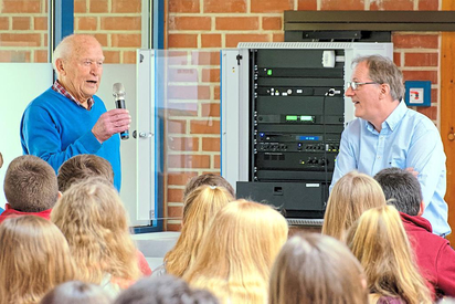 Der Zeitzeuge des Weltkrieg-Endes in Saerbeck, Alfred Maimann (links), mit Josef Berkemeier vom Heimatverein vor Schülern der MKG. Foto: Alfred Riese 