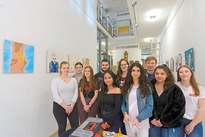 Schülerinnen und Schüler des Kunstkurses der MKG-Abiturienten zwischen den frisch aufgehängten Bildern ihrer Ausstellung unter dem Titel „Schönheitswahn“ im Rathaus-Foyer. Foto: Alfred Riese 