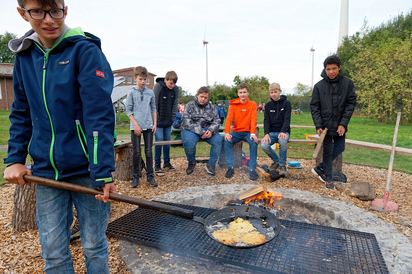 Überm offenen Feuer brutzeln Mint-Achtklässler der MKG Kartoffelpuffer für die Zweitklässler der St.-Georg-Grundschule. Foto: Alfred Riese