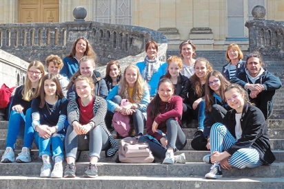 Die MKG-Schülerinnen mit ihren französischen Austauschpartnerinnen, Gasteltern und MKG-Lehrerin Cornelia Kiefhaber (2.v.r.) auf den Treppen von Fontainebleau. Foto: privat
